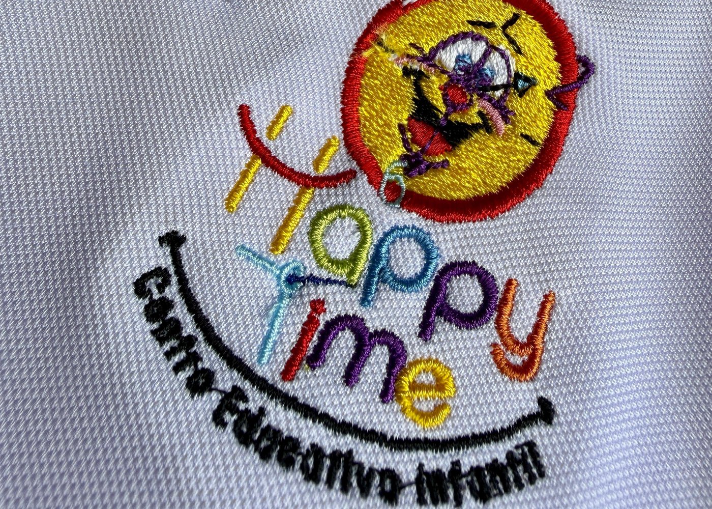 Bordado del logo Happy Time sobre el polo del uniforme escolar