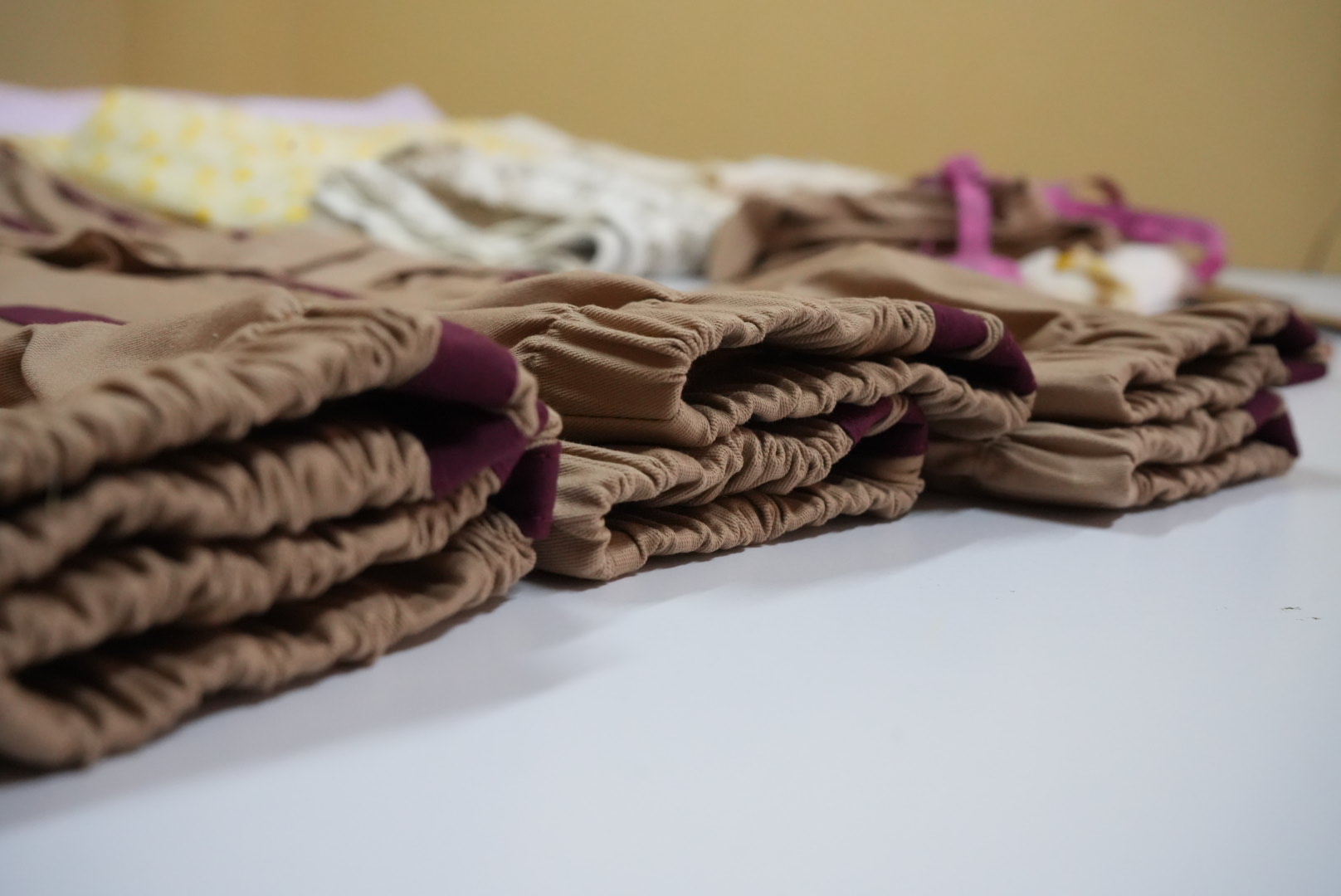 Pilas de prendas listas para entrega en el taller